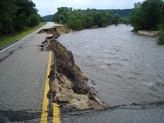 A roadway with cracked pavement due to flooding