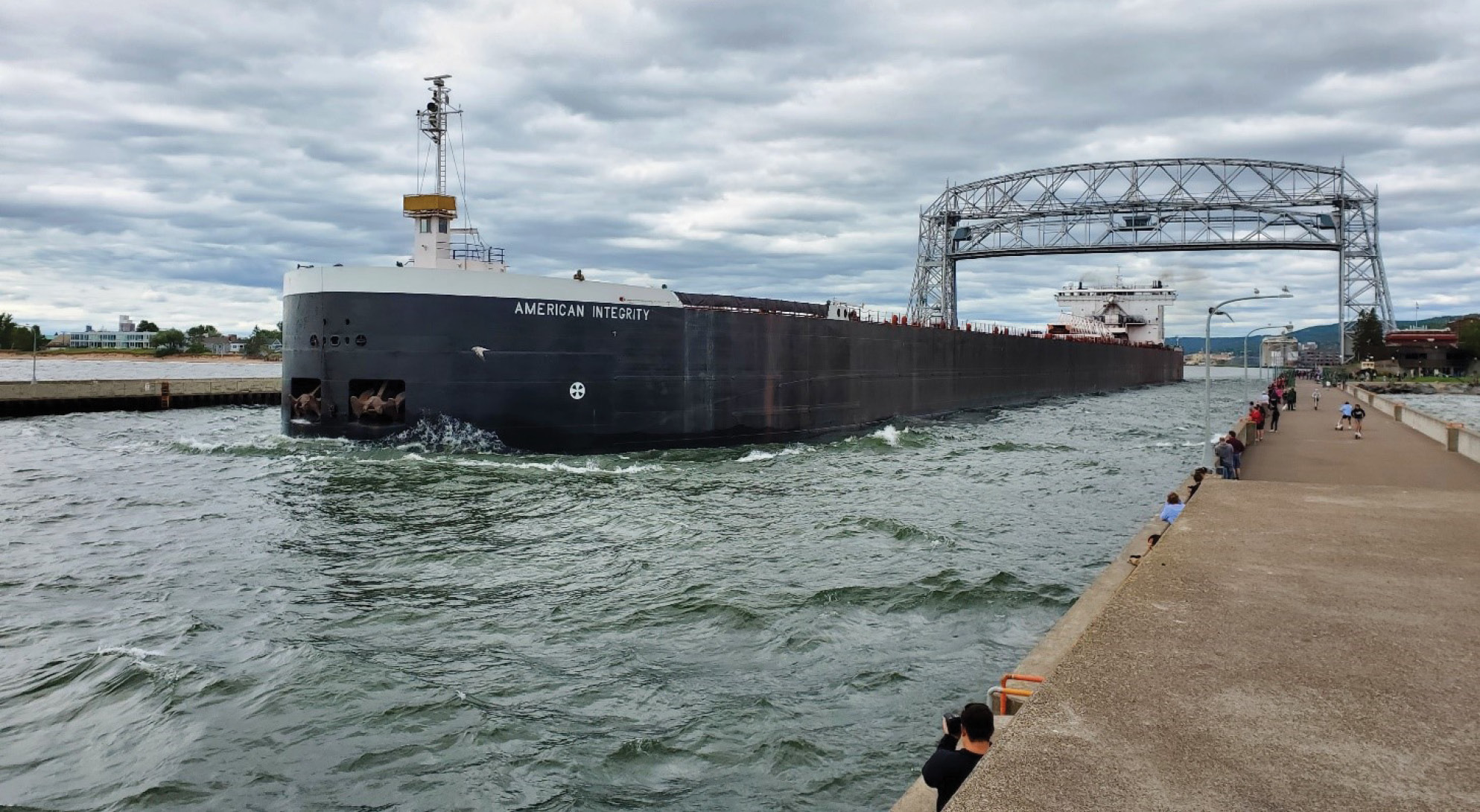 Photograph showing a lake freight exiting the Port of Duluth.